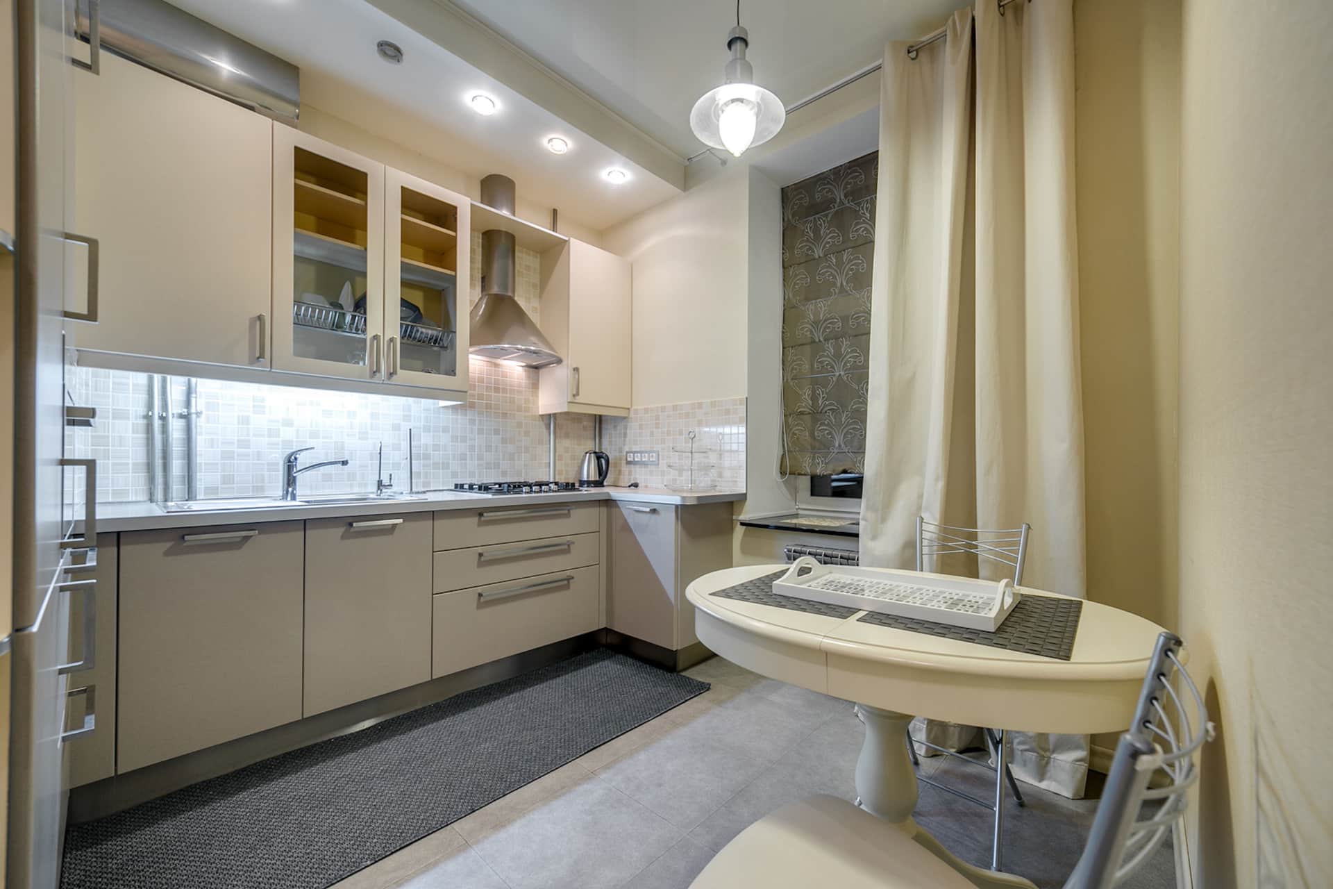 A low-profile patterned accent rug on the floor in front of a kitchen counter