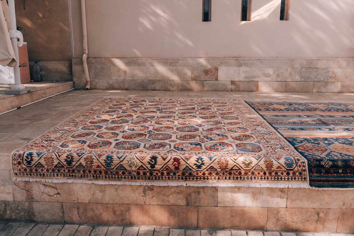 An open-weave mesh pad laid on a deck under a rug