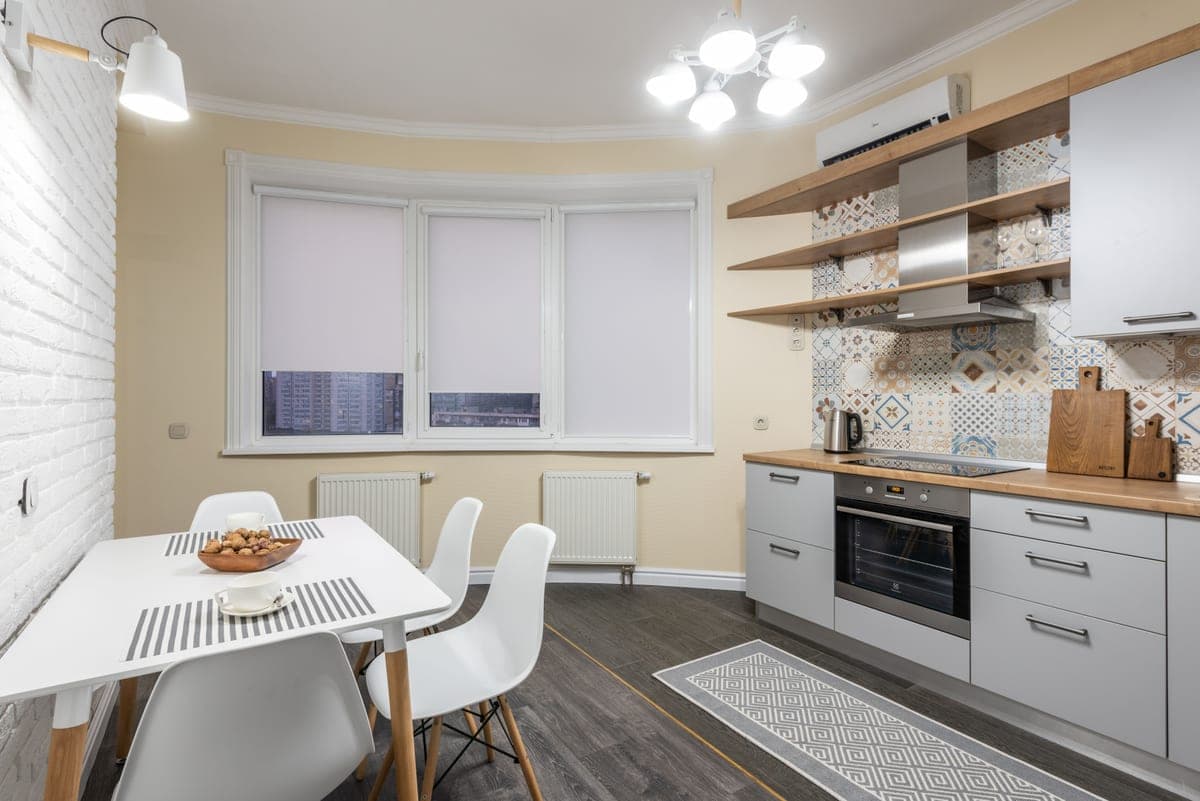 A patterned runner on a kitchen floor in front of cabinets